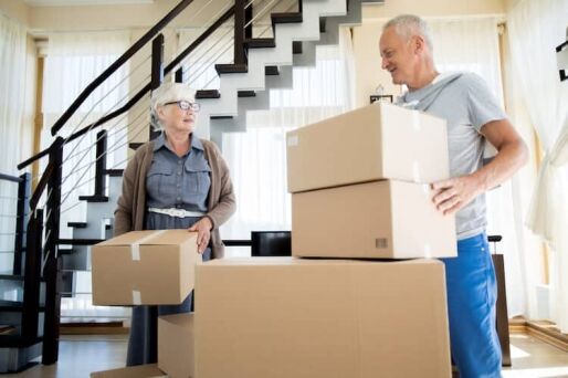 Happy senior couple packing their belongings to move to a new home.