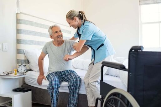 Senior man receiving help from a healthcare team member at a senior living community.