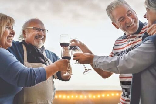 Senior friends enjoying a glass of wine at a continuing care retirement community.